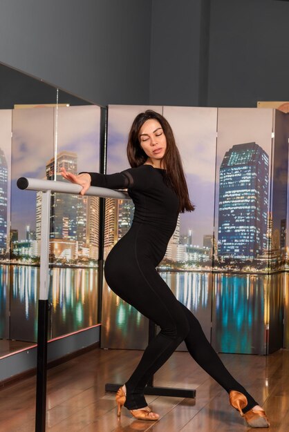 Girl in black dress are training in dance studio