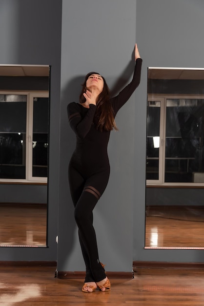 Girl in black dress are training in dance studio