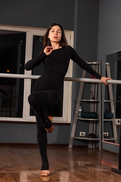 Girl in black dress are training in dance studio