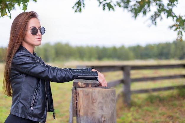 Photo girl in a black dress a hat and sunglasses outside the city