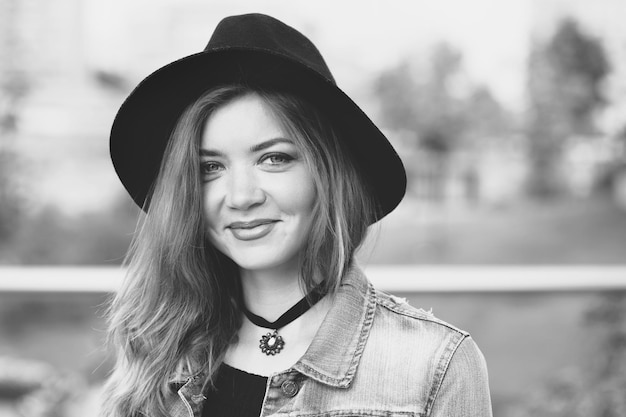 A girl in a black hat is walking in the city.