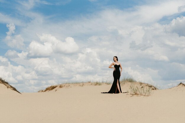 Girl in a black long dress in a sandy desert