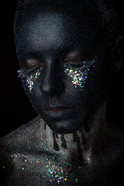 Girl in black makeup with sparkles