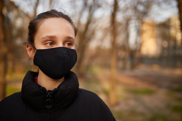 거리 검역에서 검은 의료 마스크를 쓴 소녀 자가 격리