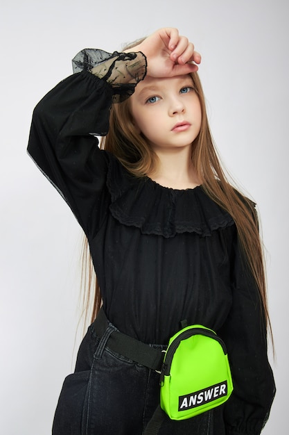 Photo girl in black outfit posing on a white background