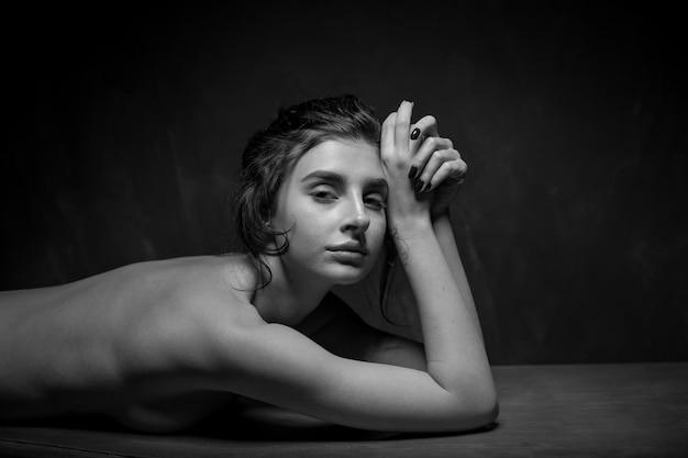 Girl in black panties with black curly hair posing in a vintage interior black and white photo