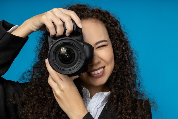 A girl in a black suit with a camera