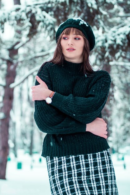 Foto ragazza in nero attraverso la neve ragazza nella neve