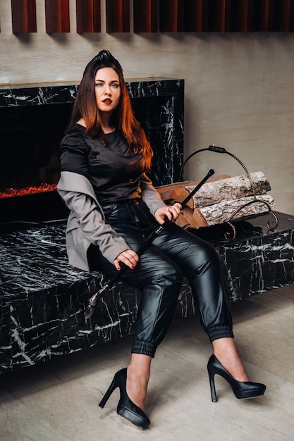 a girl in black trousers and a jacket with a cane in the interior.