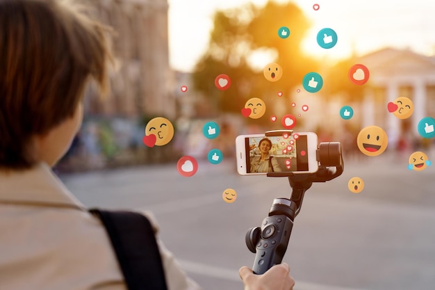girl blogger record vlog on phone selfie stick walk in city get likes emoji