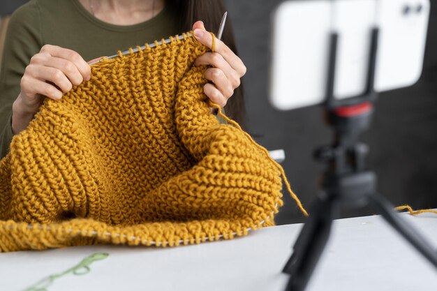 girl blogger records a video lesson on knitting close up of hands