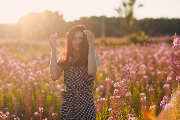 Ragazza sul giacimento di fiore di fioritura di sally. fiori lilla e donna