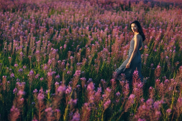 咲くサリーの花畑の女の子。ライラックの花と女性