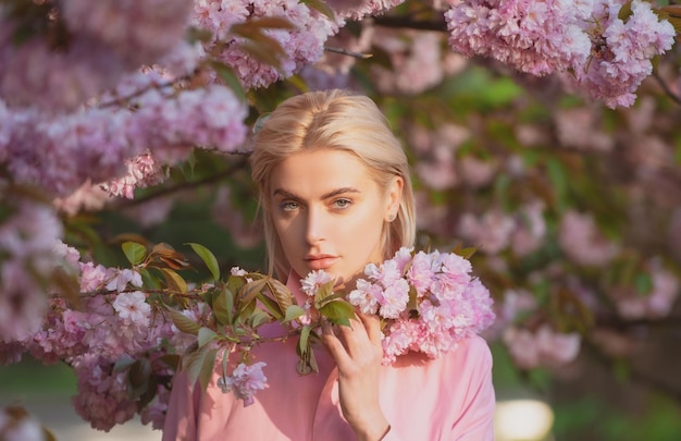 Ragazza in fiori di ciliegio sakura ritratto all'aperto di belle ragazze alla moda sensuali in posa vicino a bl...