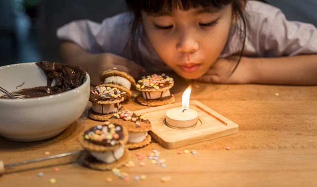 girl blow candle with handmade bakery 