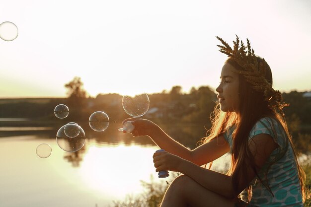 Foto ragazza che soffia bolle sul lago