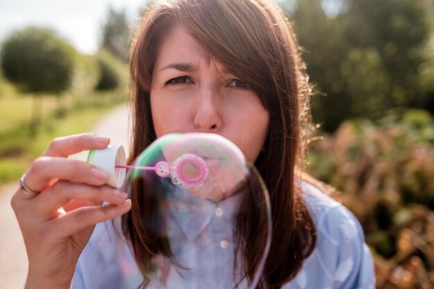 Photo girl blowing bubbles outdoor focus on lips