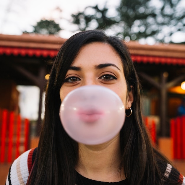 Photo girl blowing chewing gum