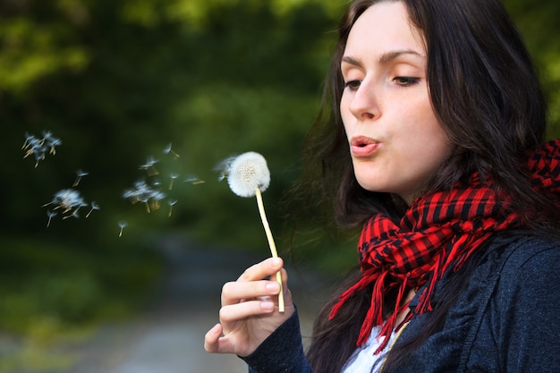 Ragazza che soffia sul dente di leone