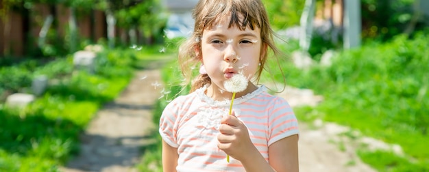 Girl blowing dandelions in the air. 