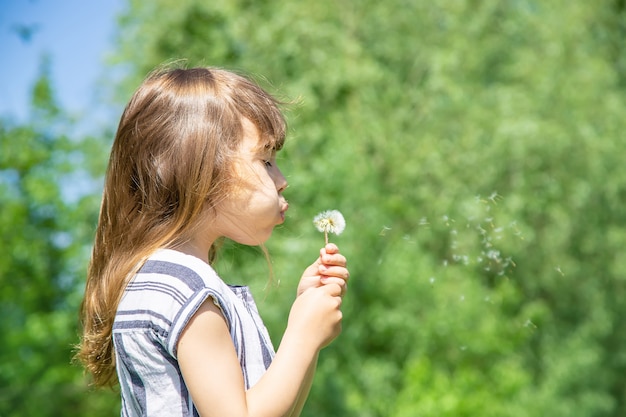 Girl blowing dandelions in the air.