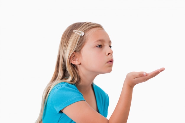 Girl blowing a kiss against a white background