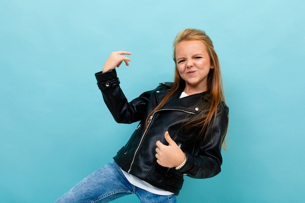 Photo girl on a blue background with her hands imitates playing the guitar