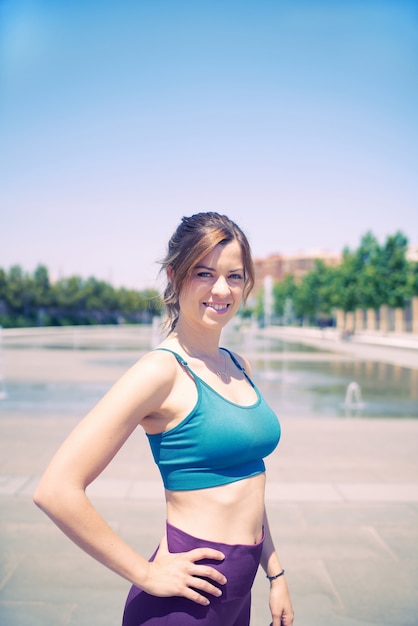 Девушка в синем бюстгальтере улыбается во время перерыва в тренировке, портретное изображение здорового образа жизни