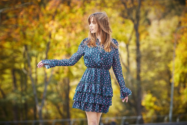 A girl in a blue dress on the background of an autumn park