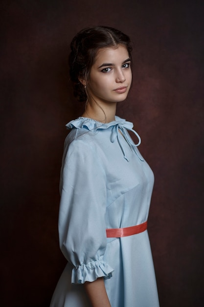 Girl in a blue dress on a dark background