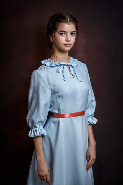 Ragazza in un vestito blu su un'oscurità