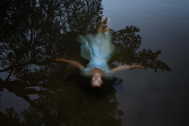 a girl in a blue dress under the watersuicide of a woman on the lake