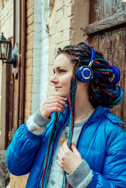 Girl in blue listening to music on headphones