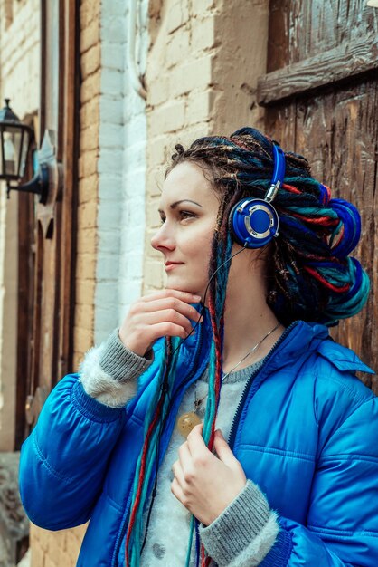 Girl in blue listening to music on headphones