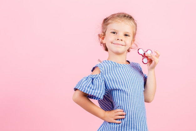 Girl in blue stripped shirt is playing red spinner in hand