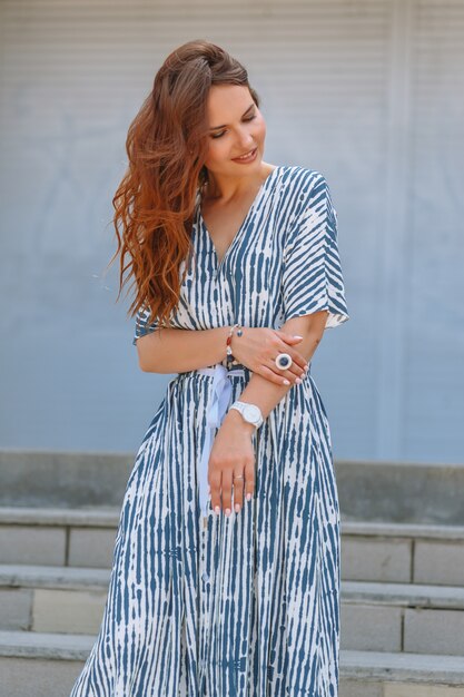 A girl in a blue and white dress on the stairs