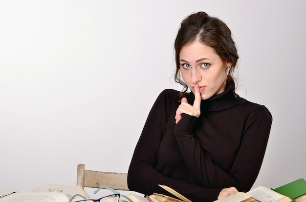 girl books exam black sweater difficulties teaches at the table tired rejoices emotions