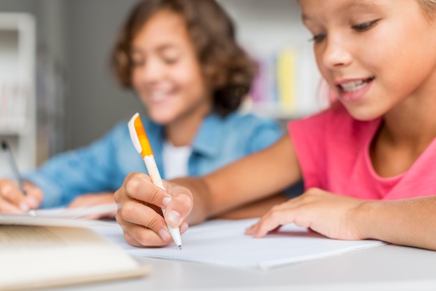 Foto ragazza e ragazzo che fanno i compiti insieme in biblioteca