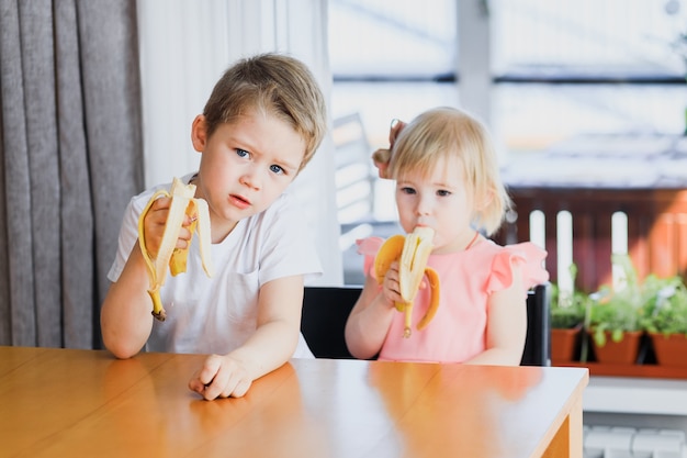 Una ragazza e un ragazzo che mangiano una banana.