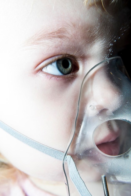 소녀는 마스크로 숨을 쉬며 어린이의 폐 질환