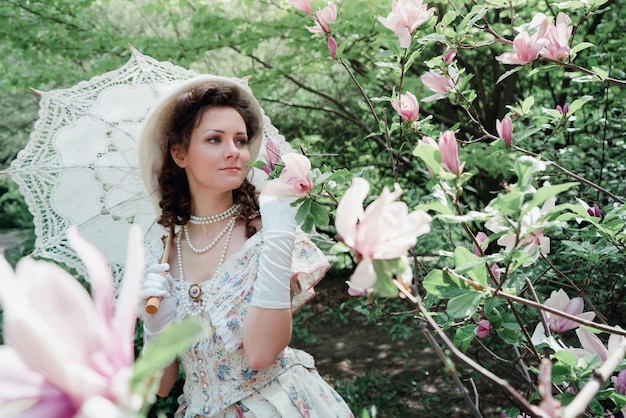 Foto sposa della ragazza vicino all'albero di fioritura