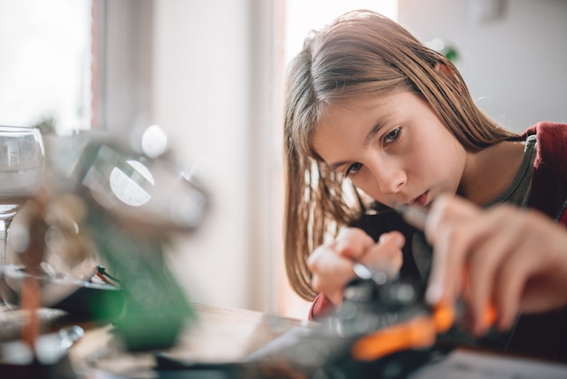 Girl building a robot at home