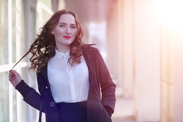 Girl business woman in the spring on a walk in a coat outdoor