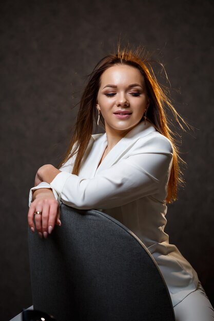 Girl businesswoman in a white jacket with beautiful hair and a smile