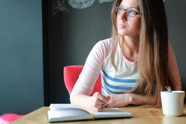 Girl in a cafe for a cup of coffee with the notebook