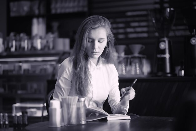 カフェの女の子がコーヒーを飲んでいます。女性がレストランで朝食をとっています。女の子のための喫茶店での朝のコーヒー。