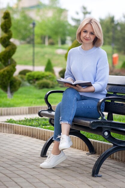 девушка в кафе на улице читает книгу