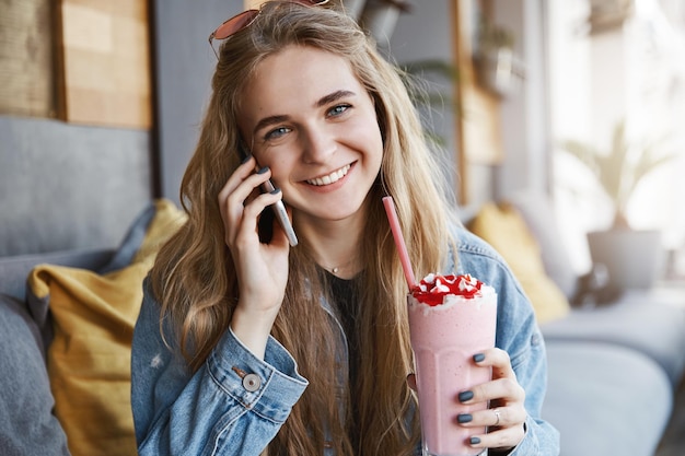 Girl calling friend asking her come over drinking tasty cocktai