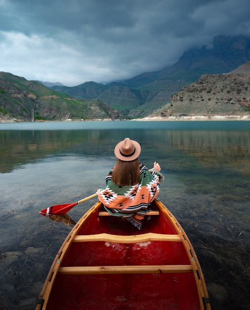 girl canoeing on a lake in the mountains on a cloudy day moody atmosphere on lake bylym