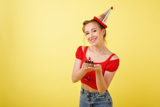 帽子の少女は黄色のスペースで誕生日を祝う